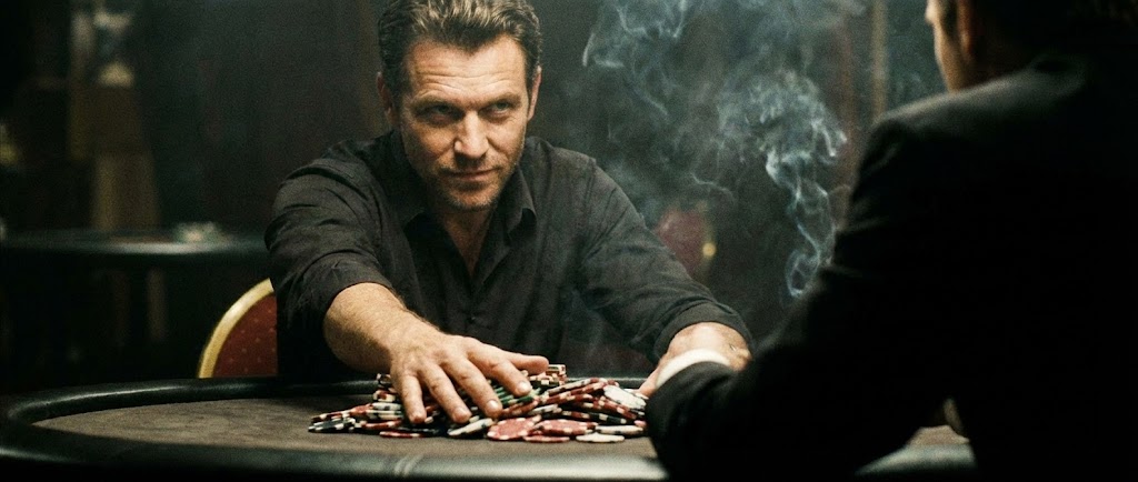 "텍사스 홀덤 경기 중 칩 더미를 과감하게 베팅(Betting)하여 상대방을 압박하는 프로 포커 플레이어의 손과 강렬한 눈빛을 담은 시네마틱 사진"